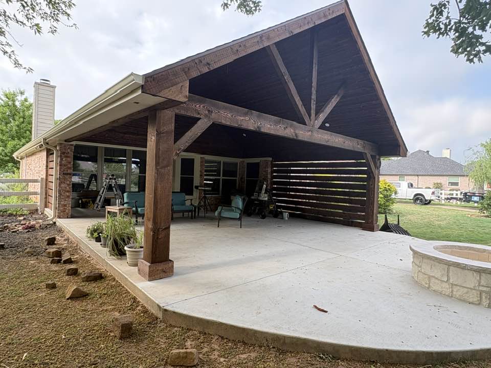 Full stained exterior with slat screen and fire pit on rounded concrete patio